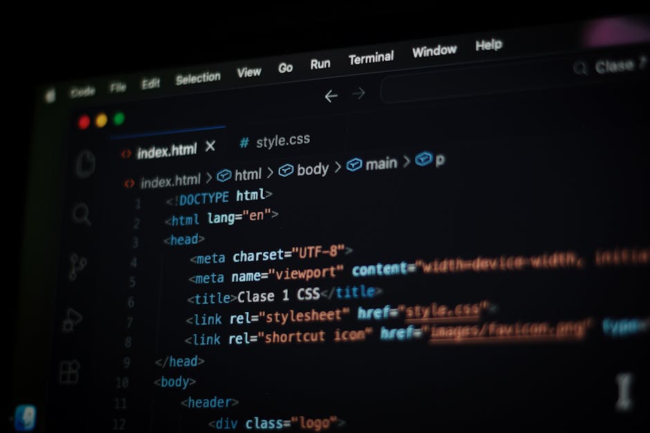 In the foreground of the image, a laptop screen displays a web development code editor with lines of HTML and CSS code visible, highlighting a dark theme with syntax in multiple colors such as red, bl